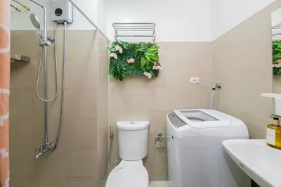 a bathroom with a shower and a toilet and a sink at 3 Condos*8 Beds*3 bathrooms*3 Kitchens*4 Pools*@ Shore2 MOA in Manila
