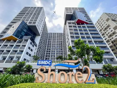 a store sign in front of two tall buildings at 3 Condos*8 Beds*3 bathrooms*3 Kitchens*4 Pools*@ Shore2 MOA in Manila