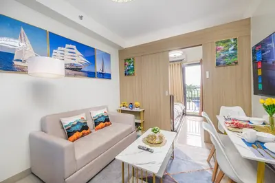 a living room with a couch and a dining room at 3 Condos*8 Beds*3 bathrooms*3 Kitchens*4 Pools*@ Shore2 MOA in Manila