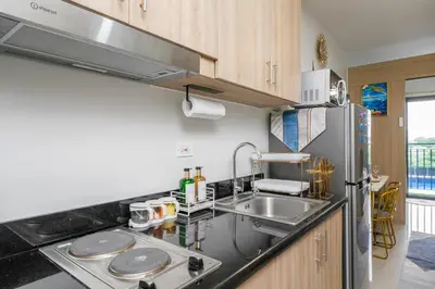 a kitchen with a sink and a refrigerator at 3 Condos*8 Beds*3 bathrooms*3 Kitchens*4 Pools*@ Shore2 MOA in Manila