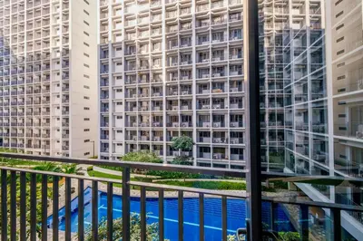 a view from the balcony of a hotel with tall buildings at 3 Condos*8 Beds*3 bathrooms*3 Kitchens*4 Pools*@ Shore2 MOA in Manila
