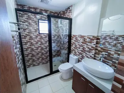 a bathroom with a toilet and a sink and a shower at Casa Maris in Bacoor