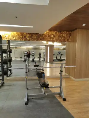 a gym with several people exercising in a gym at Shore 3 residence in Manila