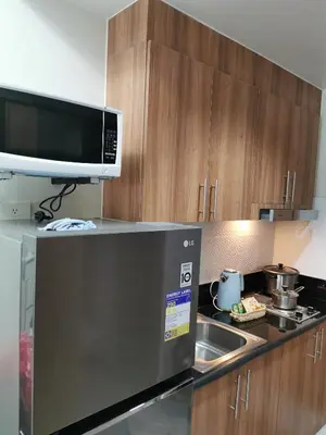 a kitchen with a microwave and a sink at Shore 3 residence in Manila