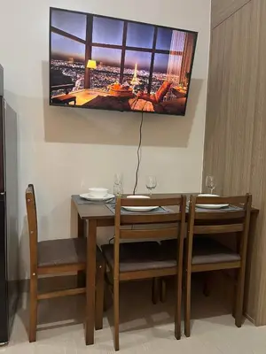 a dining room table with two chairs and a tv on the wall at Casa Florencia in Manila