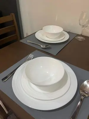 two white plates on a table with forks and spoons at Casa Florencia in Manila