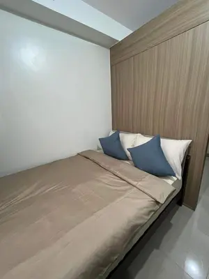 a bedroom with a bed with two blue pillows at Casa Florencia in Manila