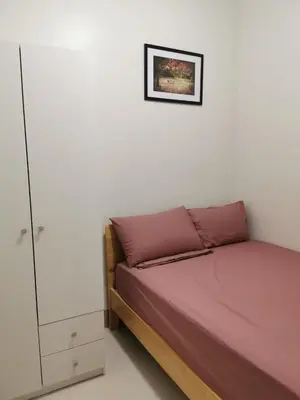 a small bedroom with a bed and a cabinet at Good Day staycation shore 3 in Manila