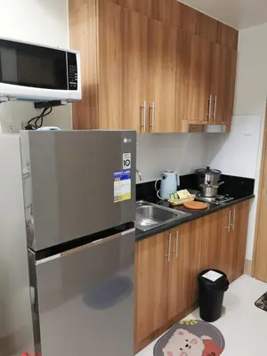 a kitchen with a refrigerator and a sink at Good Day staycation shore 3 in Manila