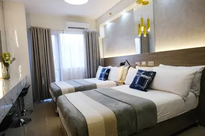 a hotel room with two beds and a mirror at Modern Studio Condo near Mall of Asia & Airport, Shore 2 Residences in Manila