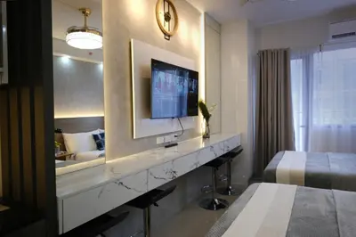 a hotel room with a television and a bed at Modern Studio Condo near Mall of Asia & Airport, Shore 2 Residences in Manila