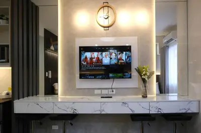 a living room with a television on a wall at Modern Studio Condo near Mall of Asia & Airport, Shore 2 Residences in Manila