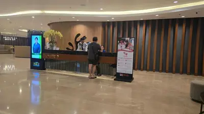 a man standing at a counter in a hotel lobby at Modern Studio Condo near Mall of Asia & Airport, Shore 2 Residences in Manila