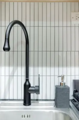 a kitchen sink with a black kitchen faucet at Shore 3 Mall of Asia - Sofian Suites in Manila