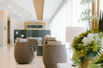 a lobby with chairs and flowers in a room at Shore 3 Mall of Asia - Sofian Suites in Manila