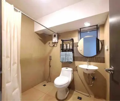 a bathroom with a toilet and a sink and a mirror at BGC - Two Bedroom Condo with Game Room with 400mbps WiFi- 09 in Manila