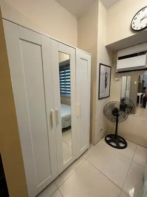 a room with white cabinets and a clock on the wall at Elane's Staycation -Mezza 2 1 br in Manila