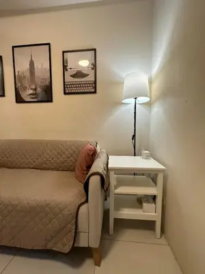 a room with a bed and a table with a lamp at Elane's Staycation -Mezza 2 1 br in Manila