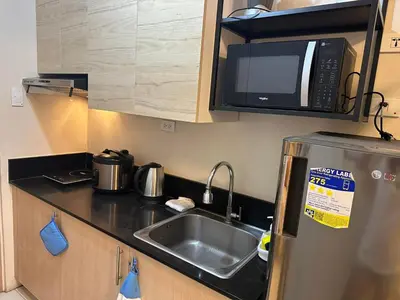a small kitchen with a sink and a microwave at Elane's Staycation -Mezza 2 1 br in Manila