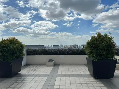 a balcony with two plants and a sky with clouds at Elane's Staycation -Mezza 2 1 br in Manila