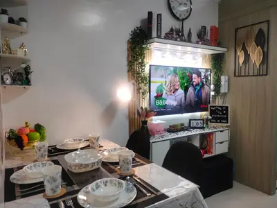 a living room with a table with plates and a tv at Smdc Breeze Residence in Manila