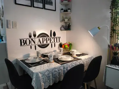 a dining room table with a white table cloth and chairs at Smdc Breeze Residence in Manila