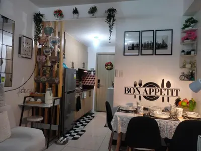 a dining room with a table and a kitchen at Smdc Breeze Residence in Manila
