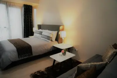 a bedroom with a bed and a couch at Eighty One Building C53J Condotel in Manila