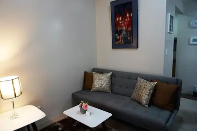 a living room with a couch and two tables at Eighty One Building C53J Condotel in Manila