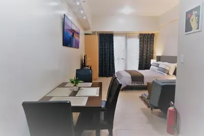 a room with a bed and a dining table and a bedroom at Eighty One Building C53J Condotel in Manila