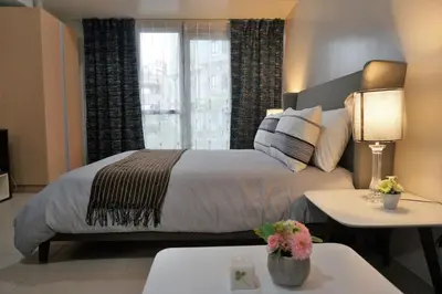 a bedroom with a large bed and a window at Eighty One Building C53J Condotel in Manila