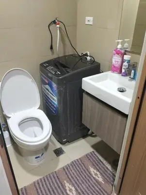 a bathroom with a toilet and a sink at Cozy Condo near Mall of Asia in Manila