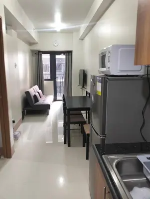 a room with a kitchen and a living room at Cozy Condo near Mall of Asia in Manila