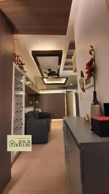 a kitchen and a living room with a couch at Condo in McKinley Hill near Grand Canal Mall (Balai Bellini) in Manila