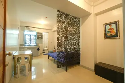 a living room with a table and chairs in a room at Backpackers Transient Room in Manila