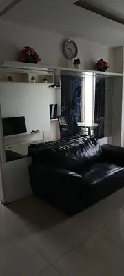 a black couch in a room with a clock on the wall at Birch Tower by The Bay in Manila