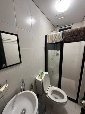 a bathroom with a toilet and a sink and a shower at The Ivory San Lorenzo Place Makati in Manila