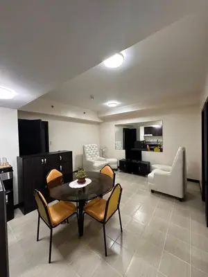 a living room with a table and chairs at The Ivory San Lorenzo Place Makati in Manila