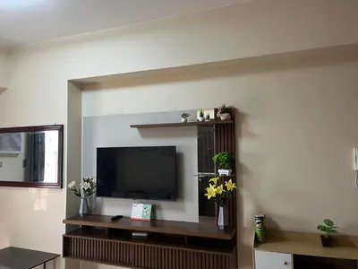 a living room with a flat screen tv on a wall at Bayfront Suite in Pasay Near NAIA Terminal, PICC, Star City, MOA and US Embassy - Pet-Friendly, Wi-Fi & Netflix, Free Swimming Pool, Sauna and Gym, Work from Home Ready in Manila