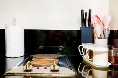 a stove top with pots and pans and utensils at Bayfront Suite in Pasay Near NAIA Terminal, PICC, Star City, MOA and US Embassy - Pet-Friendly, Wi-Fi & Netflix, Free Swimming Pool, Sauna and Gym, Work from Home Ready in Manila