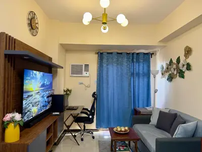 a living room with a couch and a tv at Bayfront Suite in Pasay Near NAIA Terminal, PICC, Star City, MOA and US Embassy - Pet-Friendly, Wi-Fi & Netflix, Free Swimming Pool, Sauna and Gym, Work from Home Ready in Manila