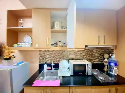 a kitchen with a sink and a microwave at Macc Staycation Shell Residences Moa in Manila