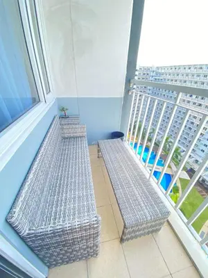 two metal benches in a room with a large window at Macc Staycation Shell Residences Moa in Manila