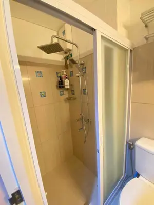 a shower with a glass door in a bathroom at Macc Staycation Shell Residences Moa in Manila
