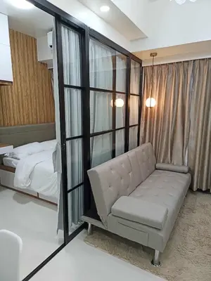 a bedroom with a couch and a bed and a window at Lian Louise at SMDC Shore 3 MOA with Parking in Manila