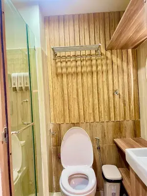 a small bathroom with a toilet and a shower at Lian Louise at SMDC Shore 3 MOA with Parking in Manila