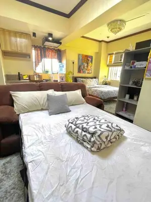a large white bed in a room with a couch at Condo in Malate Manila in Manila