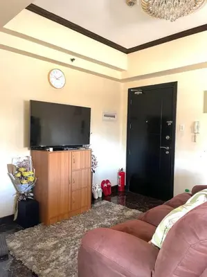 a living room with a couch and a flat screen tv at Condo in Malate Manila in Manila