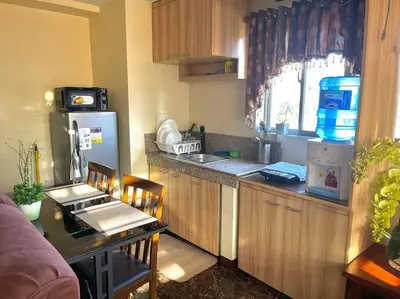 a kitchen with a refrigerator and a table with chairs at Condo in Malate Manila in Manila