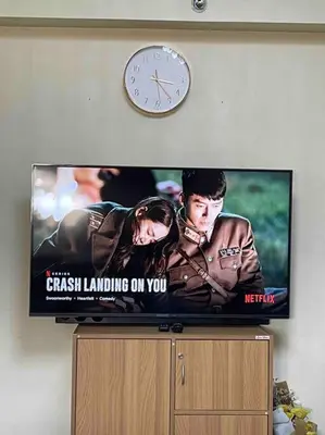 a television with a clock on a wall at Condo in Malate Manila in Manila